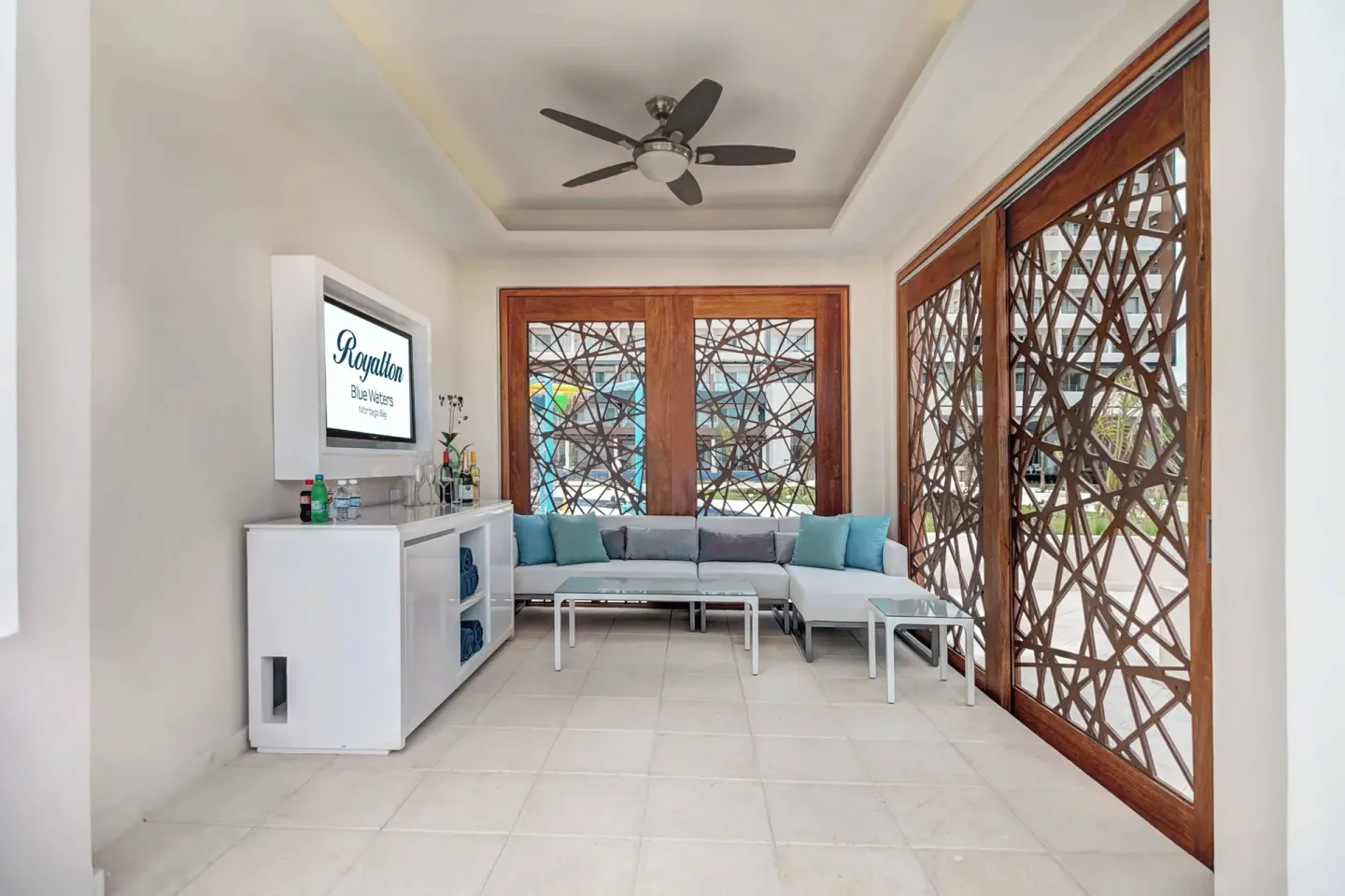 Bright resort lounge with sectional seating and lattice windows at Royalton Blue Waters Montego Bay.