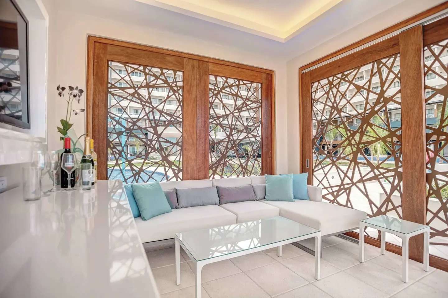 Bright lounge with white seating and patterned wood screens at Royalton Blue Waters Montego Bay.