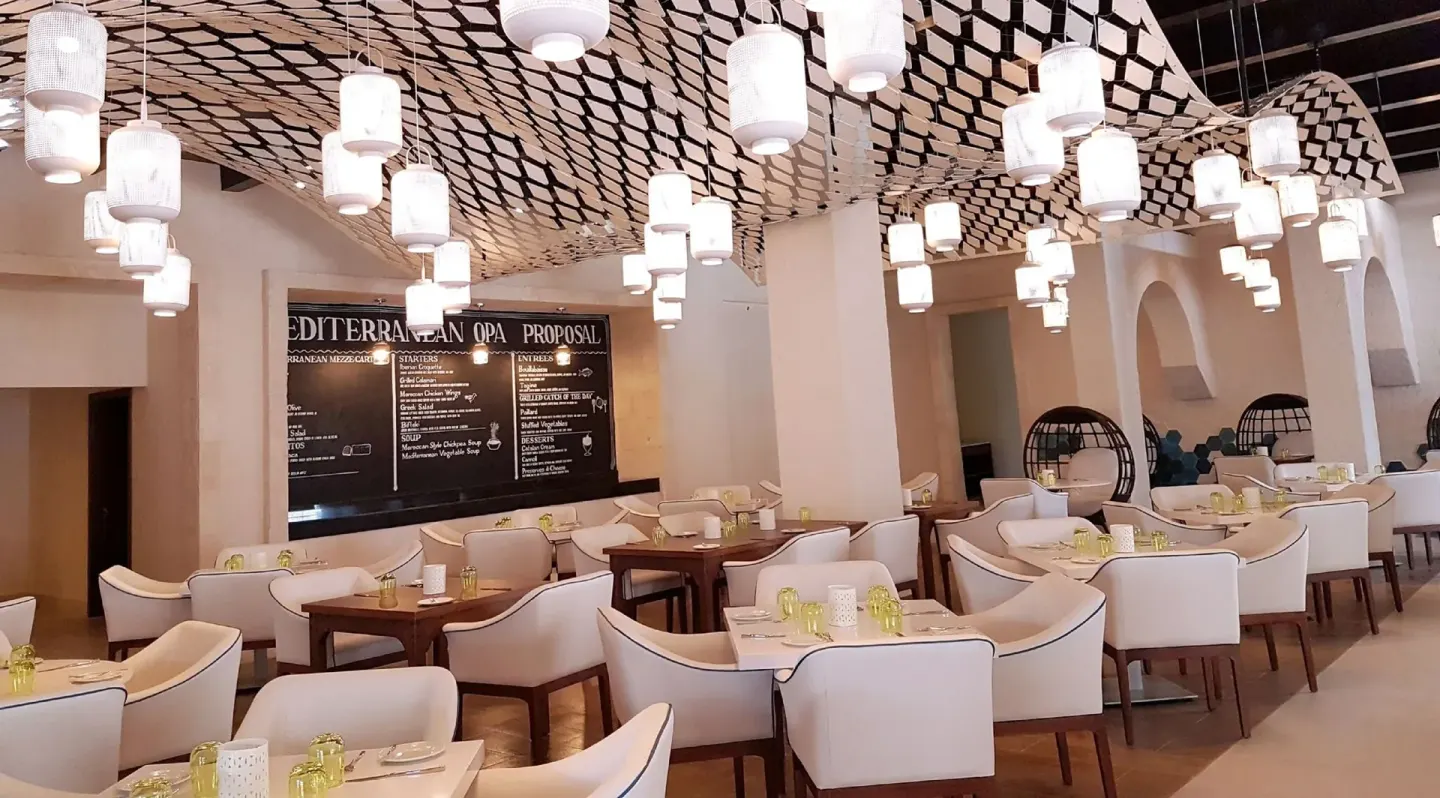 An Italian-style dining room with white chairs at Royalton Blue Waters Montego Bay.