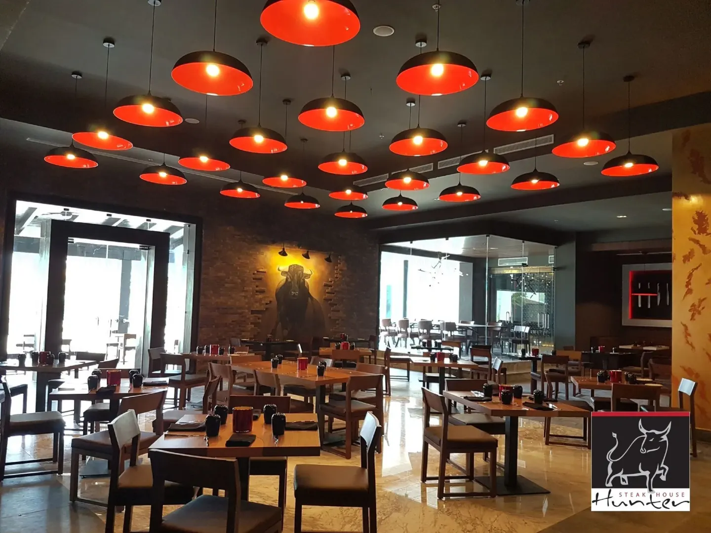 A steakhouse dining room with red pendant lights at Royalton Blue Waters Montego Bay.