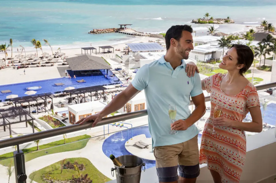 Couple on an ocean-view suite balcony at Royalton Blue Waters Montego Bay.