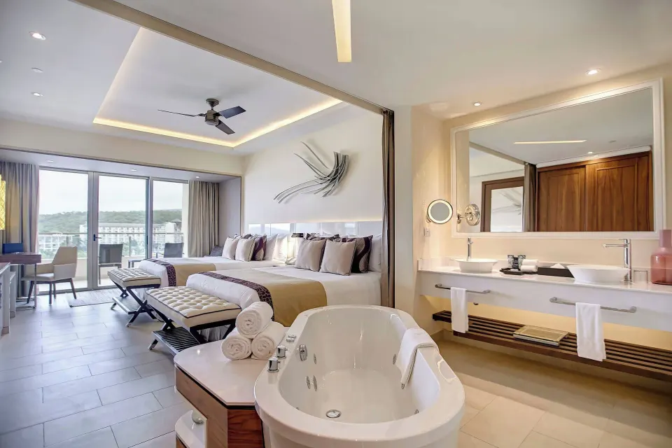 Two queen beds and soaking tub in a Luxury Junior Suite at Royalton Blue Waters Montego Bay.