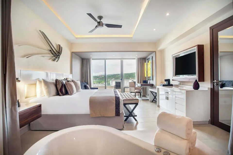 Luxury Junior Suite Swim Out bedroom and tub at Royalton Blue Waters Montego Bay.