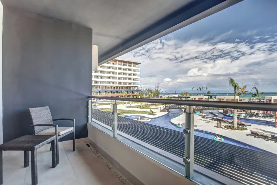 Luxury Junior Suite balcony with chairs and ocean view at Royalton Blue Waters Montego Bay.