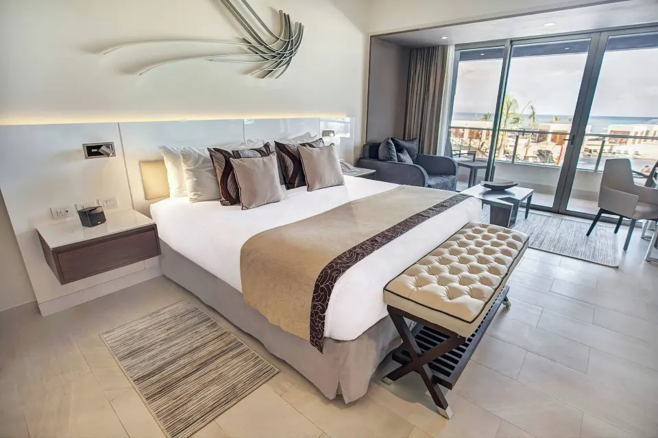 Luxury Junior Suite king bed with balcony and ocean view at Royalton Blue Waters Montego Bay.