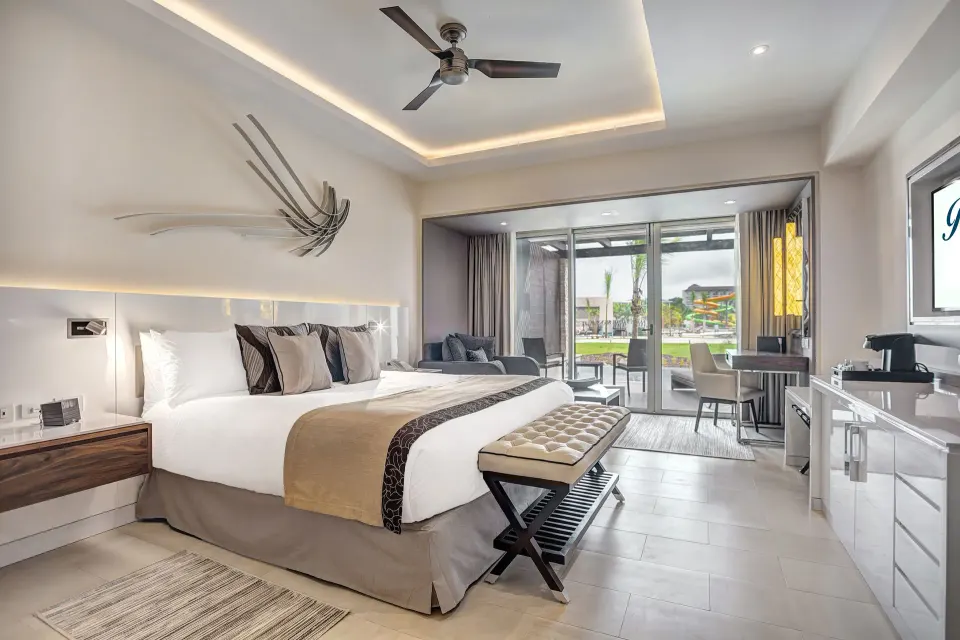 Luxury Junior Suite king bed and balcony doors at Royalton Blue Waters Montego Bay.