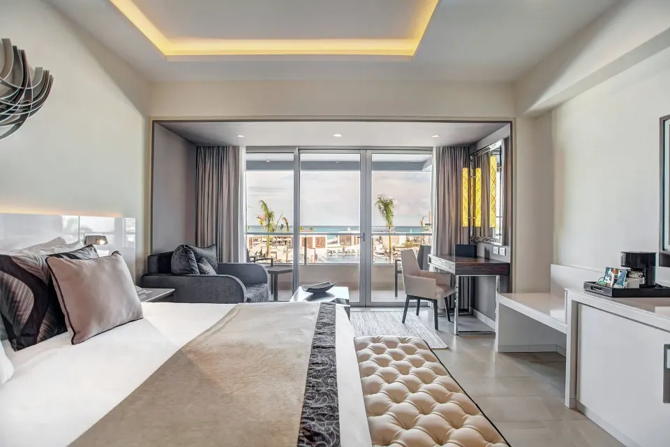 Luxury Junior Suite king bed and balcony view at Royalton Blue Waters Montego Bay.
