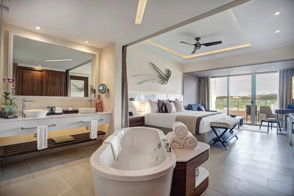 Luxury Junior Suite soaking tub, vanity and king bed at Royalton Blue Waters Montego Bay.