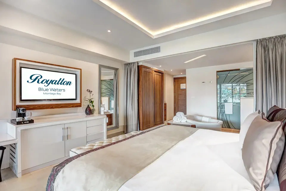 Luxury Junior Suite king bed, TV and soaking tub at Royalton Blue Waters Montego Bay.