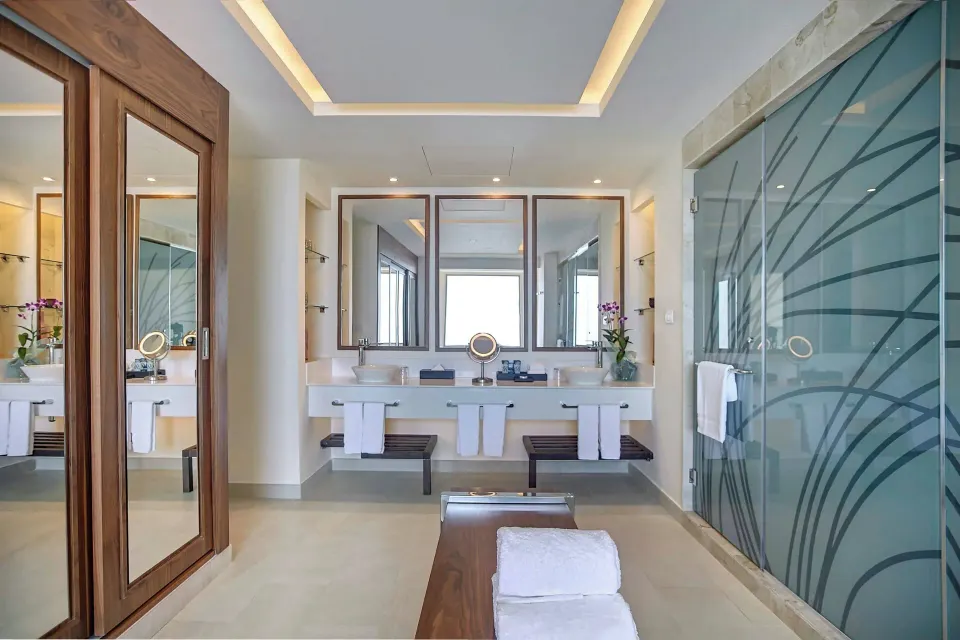 Suite bathroom with double vanity and glass shower at Royalton Blue Waters Montego Bay.