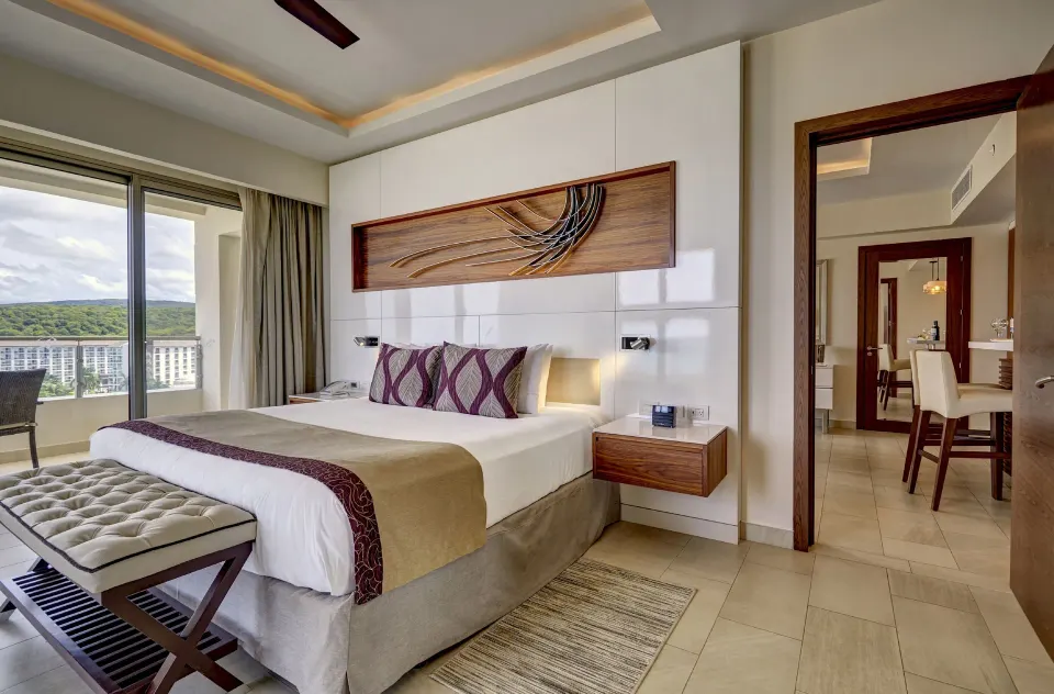 King bedroom in the suite with balcony doors at Royalton Blue Waters Montego Bay.