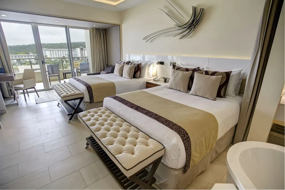 Two-bed suite bedroom with balcony at Royalton Blue Waters Montego Bay.