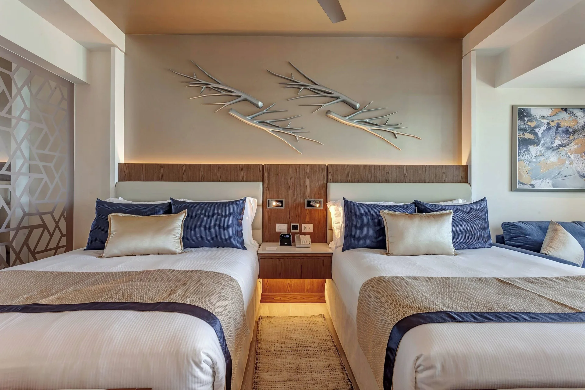 Two double beds with decorative wall art in a guest room at Royalton CHIC Cancun.