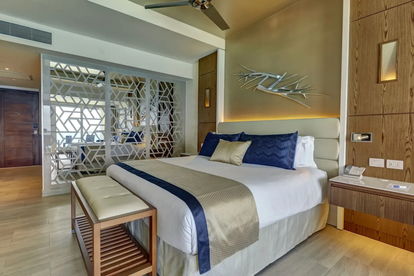 King bed guest room with patterned divider at Royalton CHIC Cancun.