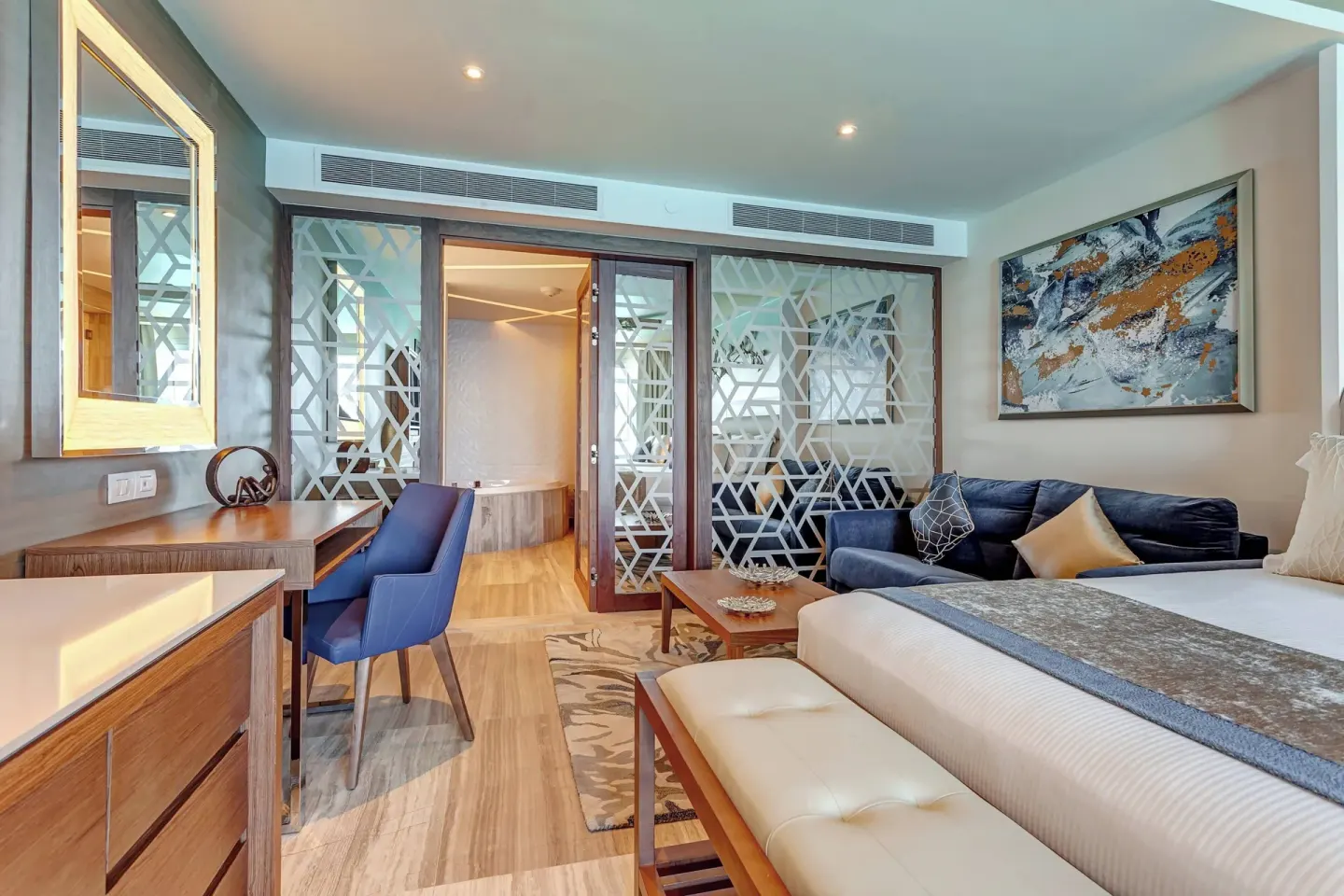 Guest room sitting area, desk, and bed at Royalton CHIC Cancun.