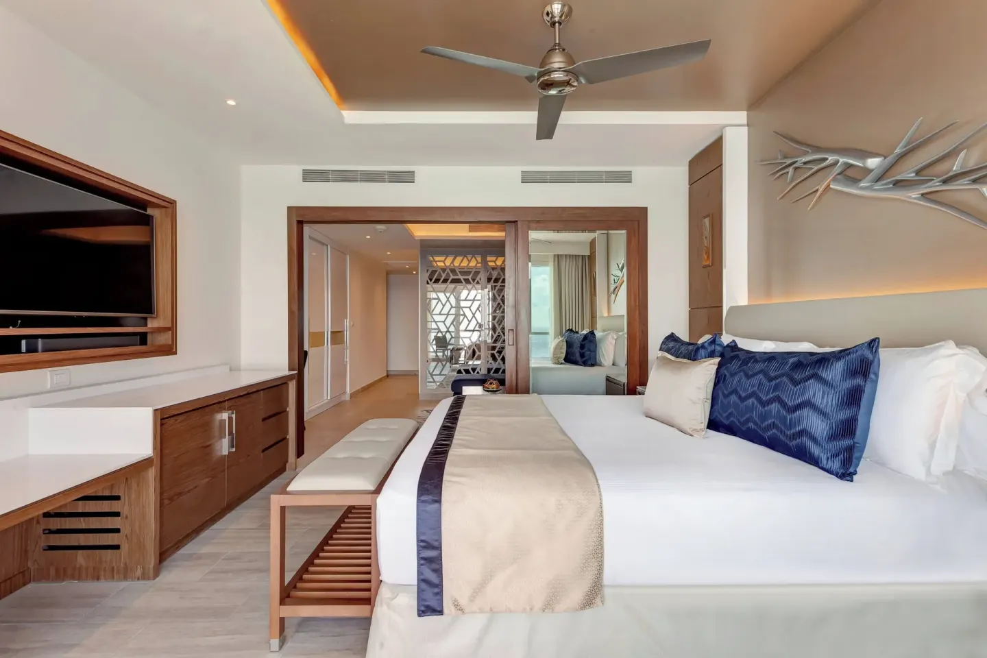 Guest room king bed with TV and wood cabinetry at Royalton CHIC Cancun.