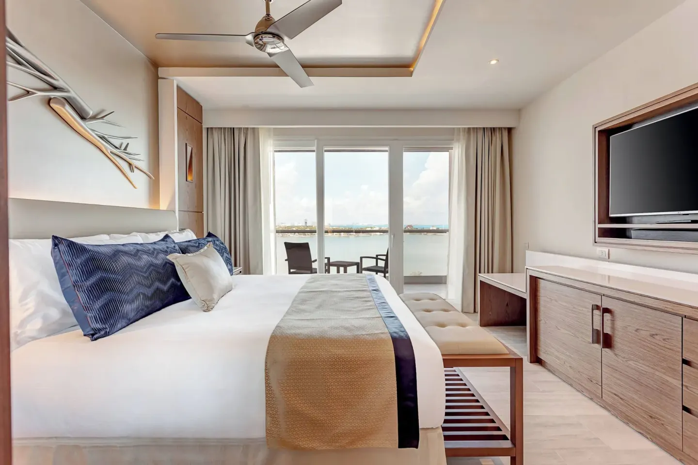 King bed guest room with balcony and lagoon view at Royalton CHIC Cancun.