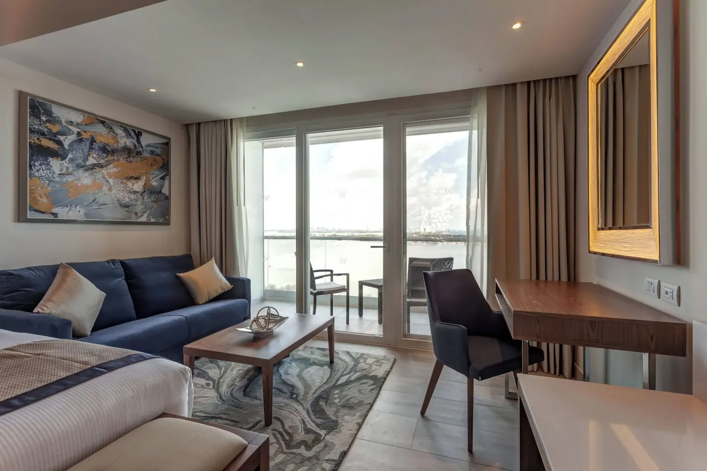 Guest room sitting area with balcony and water view at Royalton CHIC Cancun.