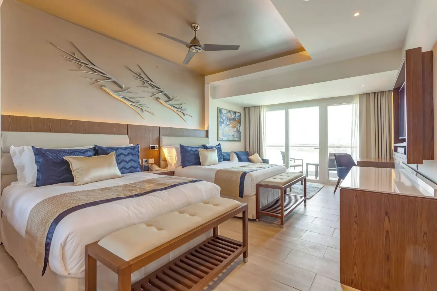Two-bed guest room with benches and balcony seating at Royalton CHIC Cancun.