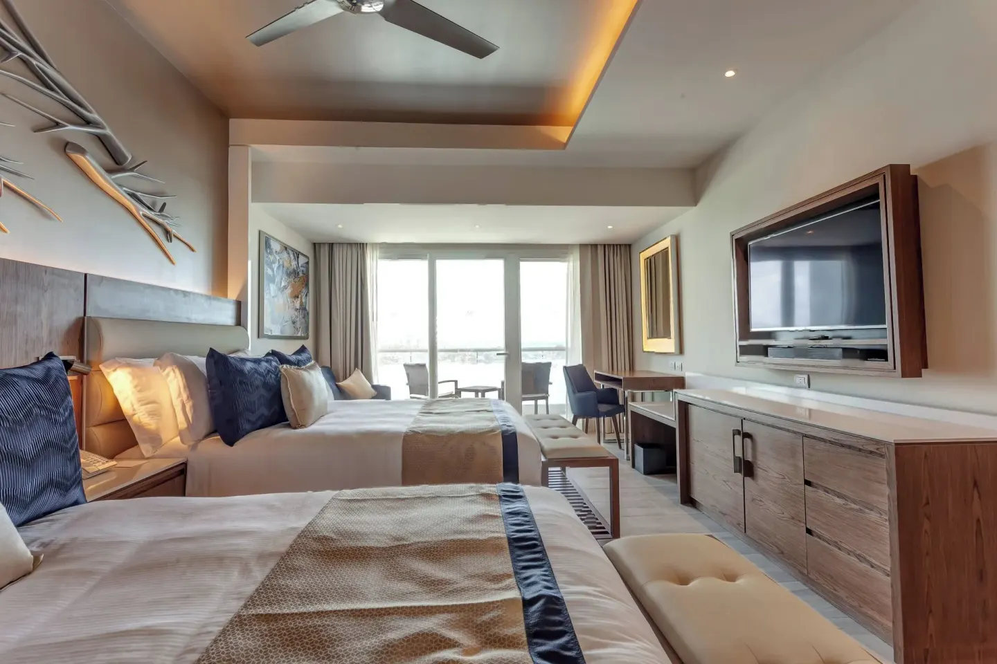 Two-bed guest room with desk and balcony doors at Royalton CHIC Cancun.