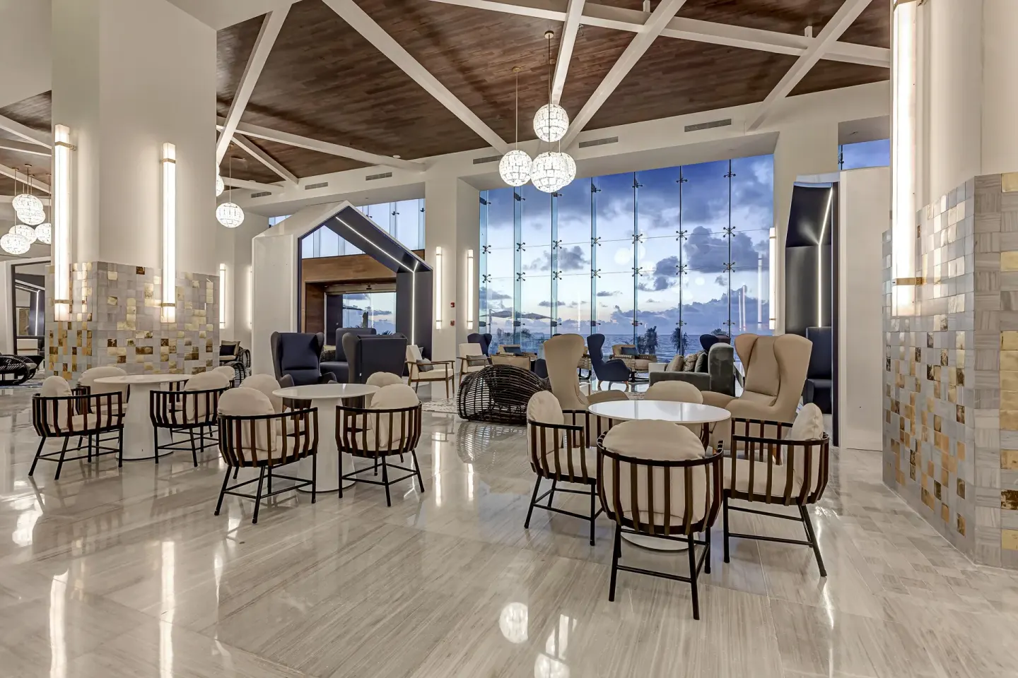 Lobby seating area with ocean-facing windows at Royalton CHIC Cancun.