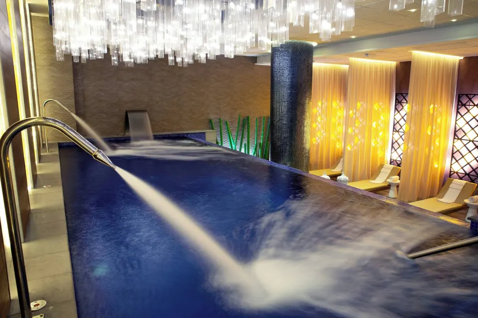 Spa hydrotherapy pool with water jets and loungers at Royalton CHIC Cancun.
