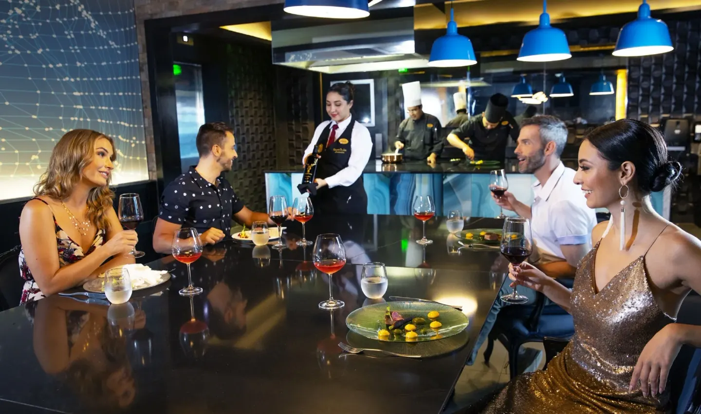 Guests dine at a chef counter with wine service at Royalton CHIC Cancun.
