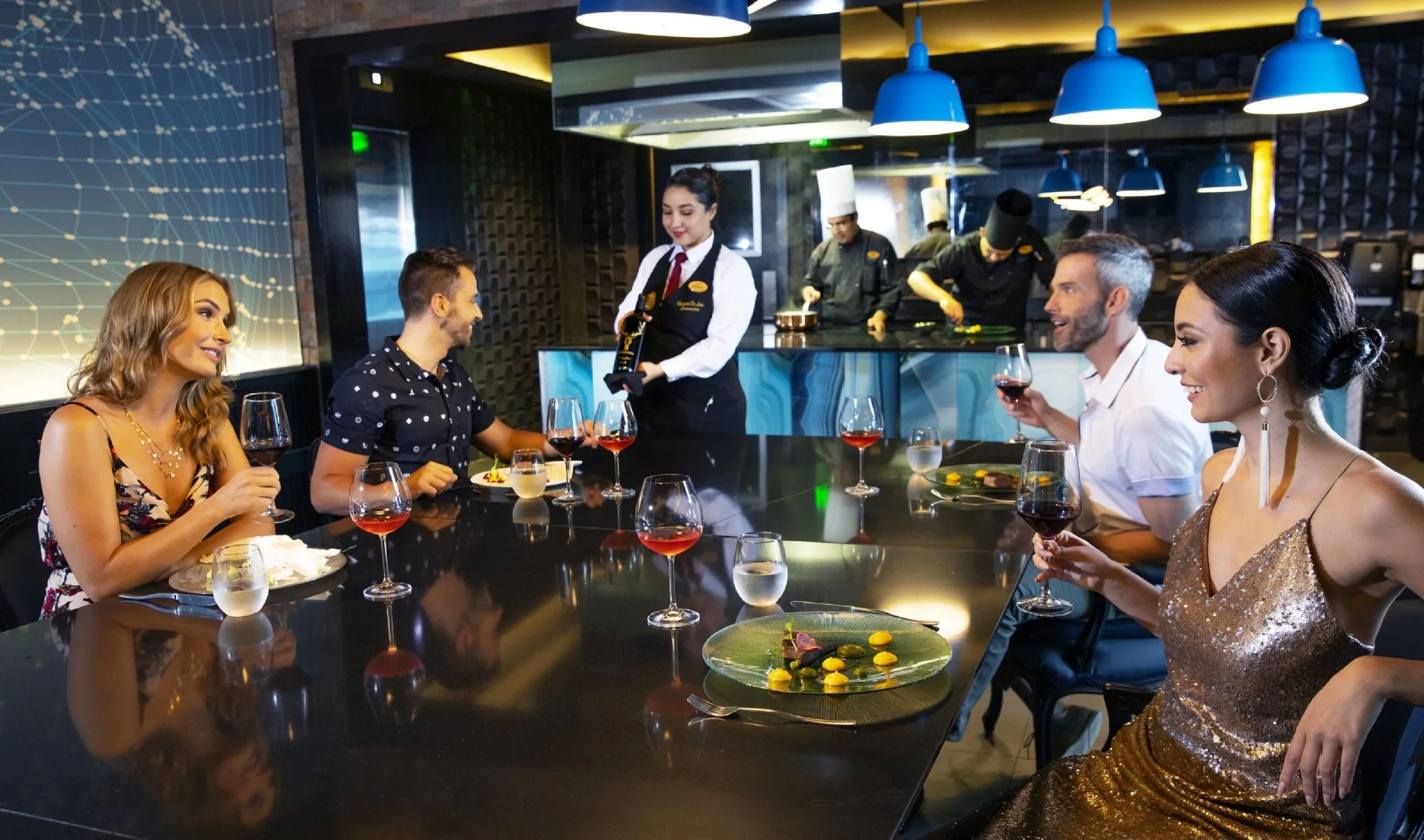 Guests dine at a chef counter with wine service at Royalton CHIC Cancun.