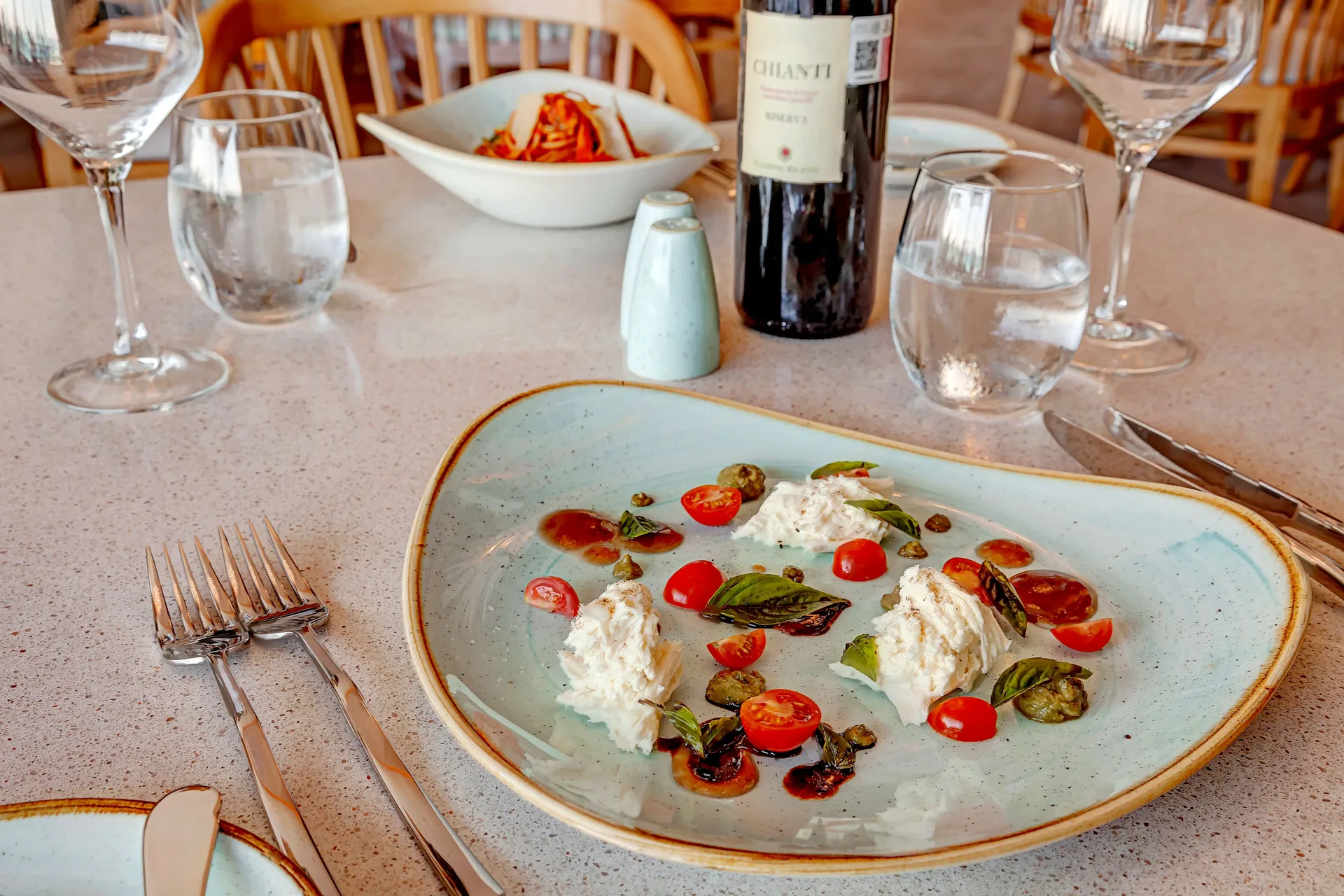 Italian-style appetizer, wine and table settings at Royalton CHIC Cancun.
