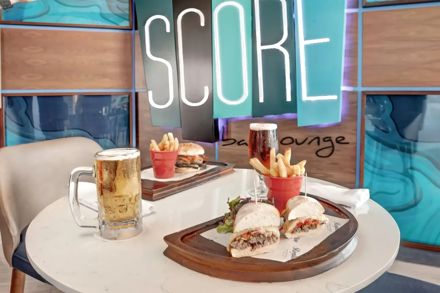 Sandwiches, fries, and beer in SCORE Sports Bar at Royalton CHIC Cancun.
