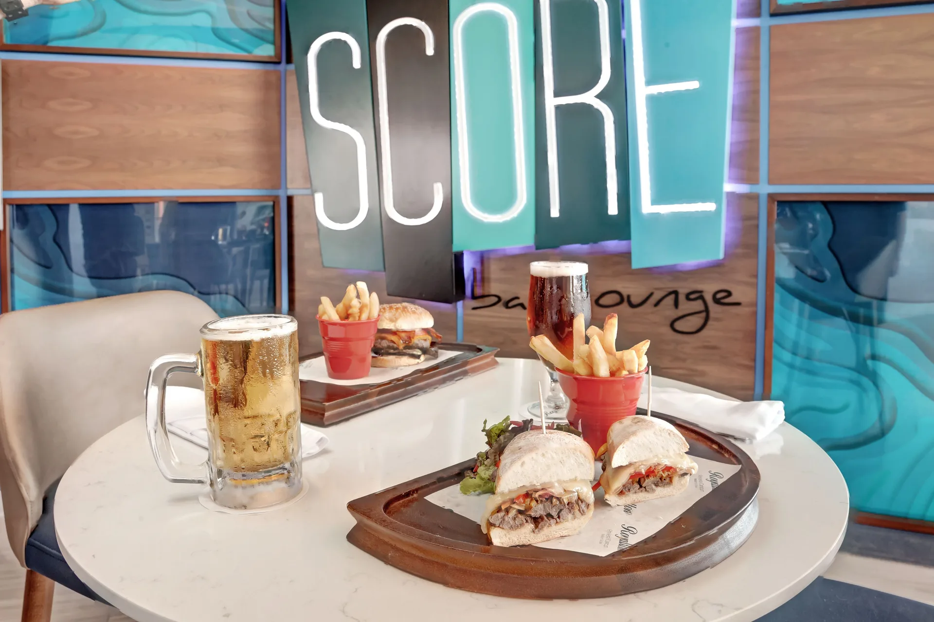 Sandwiches, fries, and beer in SCORE Sports Bar at Royalton CHIC Cancun.