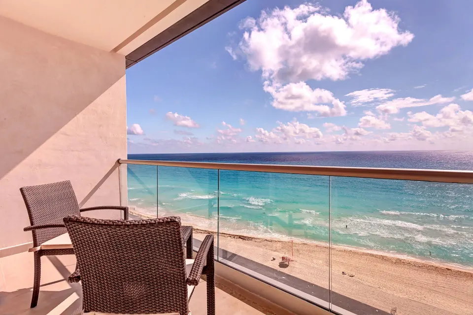 Oceanfront balcony with wicker chairs and beach view at Royalton CHIC Cancun.