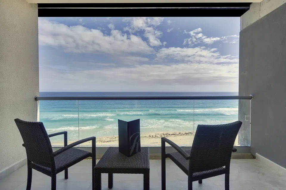 Oceanfront balcony seating for a Luxury Junior Suite at Royalton CHIC Cancun.