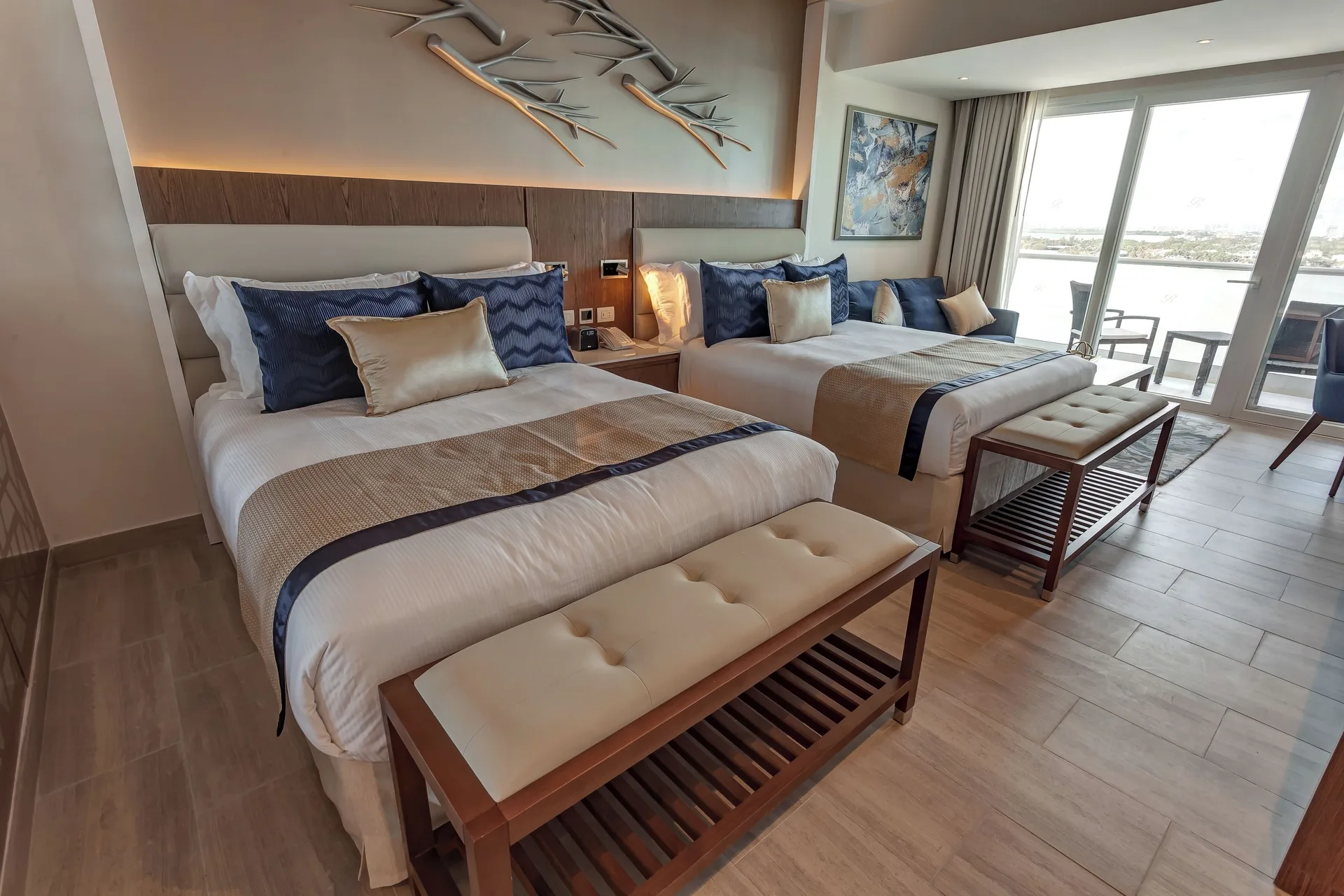 Two-bed Luxury Junior Suite Sunset View at Royalton CHIC Cancun with balcony doors.