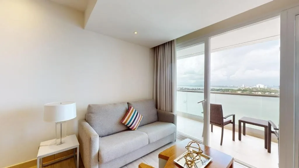 Living area and balcony view in a Presidential Two Bedroom Suite at Royalton CHIC Cancun.
