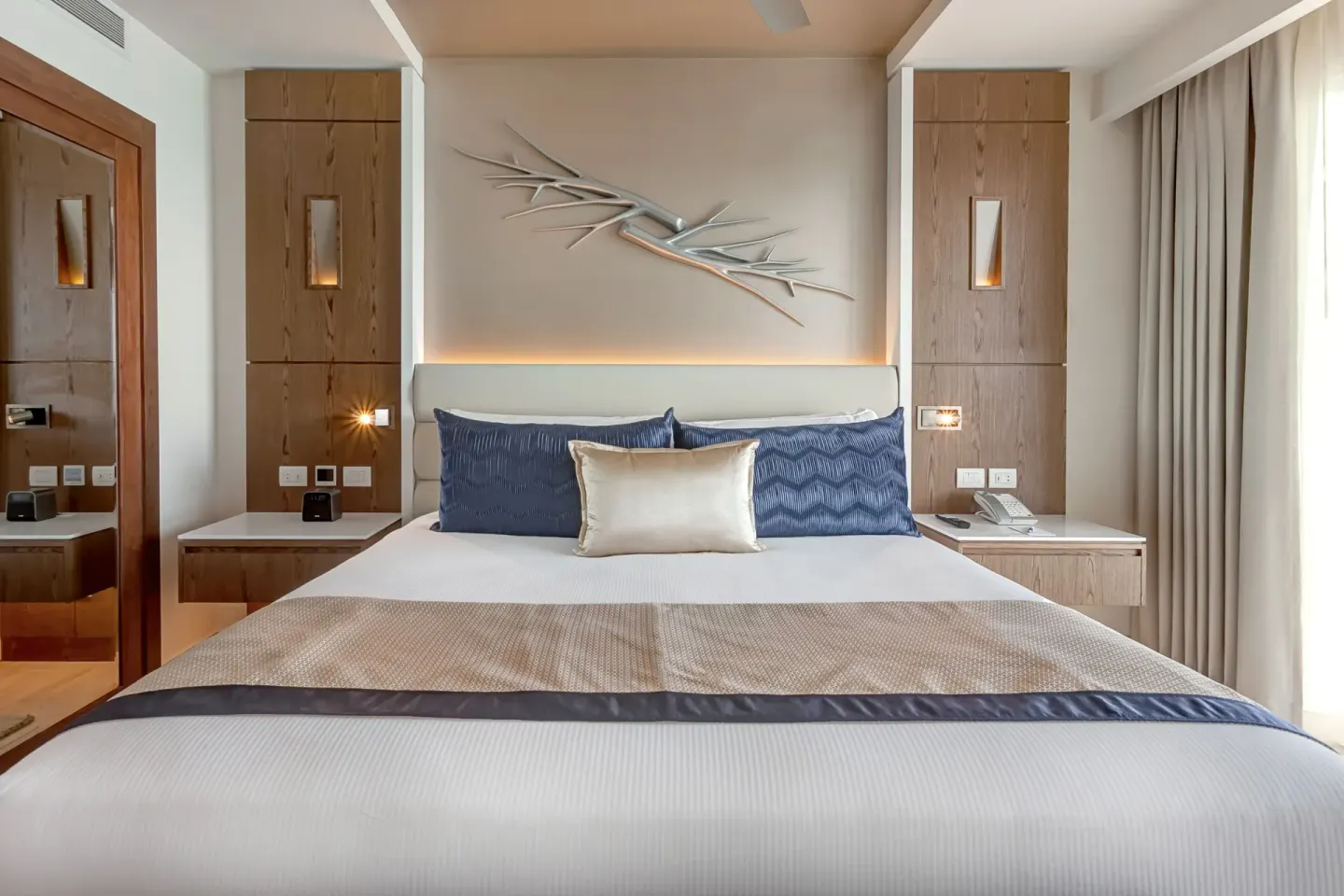 Luxury Suite Ocean Front bed with wood panels at Royalton CHIC Cancun.