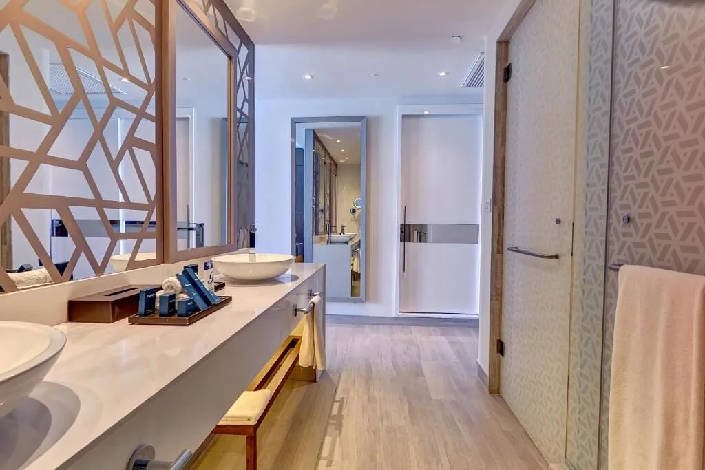 Luxury Suite Sunset View bathroom vanity and glass shower at Royalton CHIC Cancun.