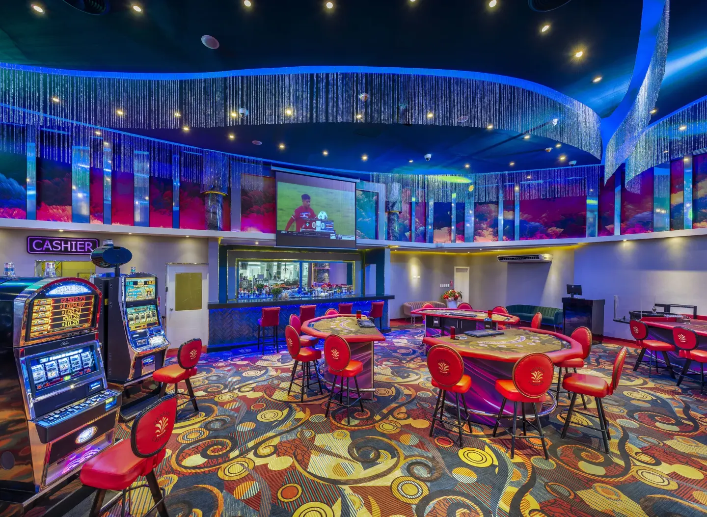 Casino gaming area at Royalton CHIC Punta Cana Resort & Casino with slot machines, tables, and cashier sign.