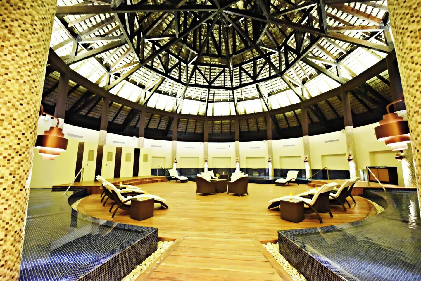 Circular hydrotherapy lounge at Royalton CHIC Punta Cana Resort & Casino with loungers and water features.