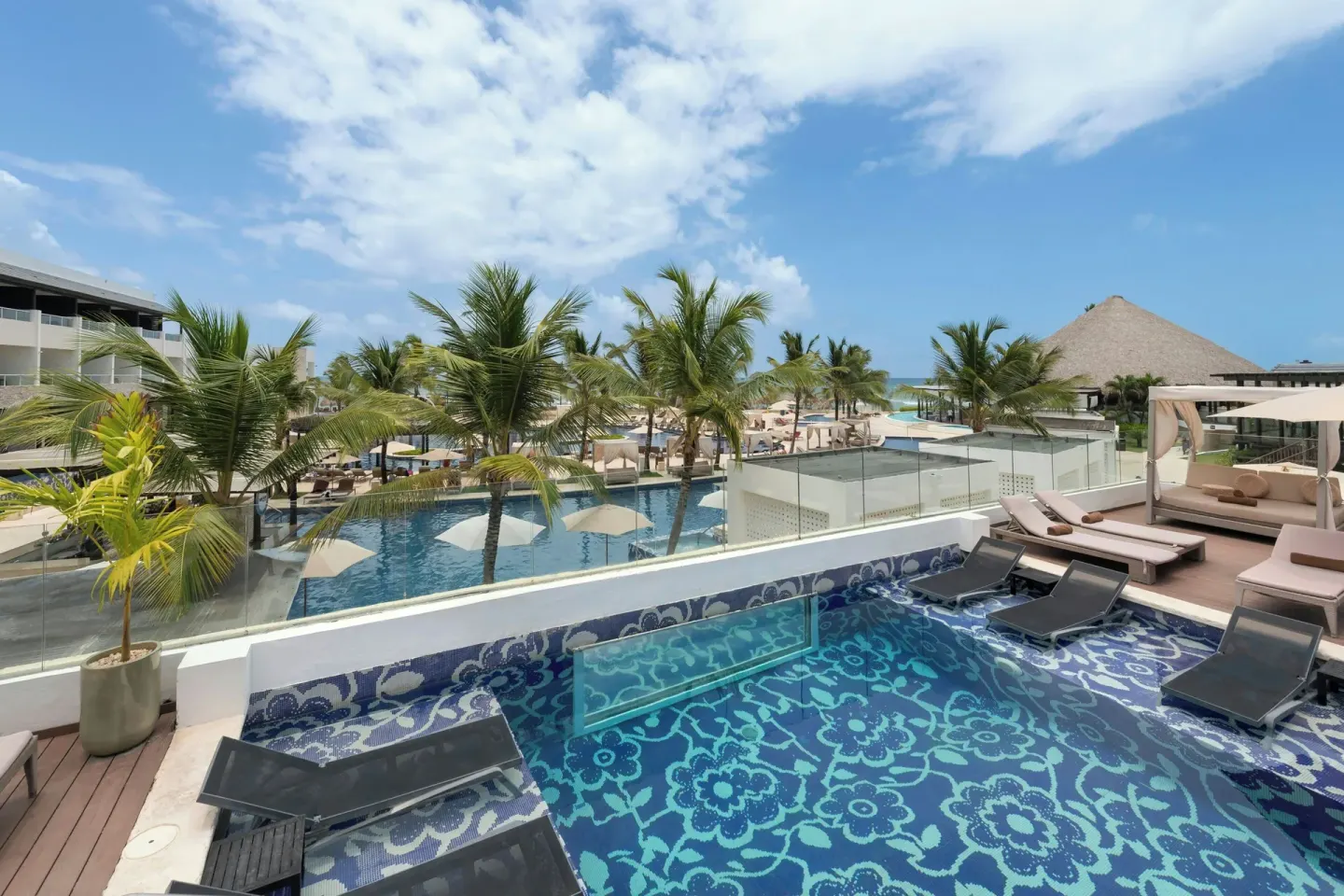 Elevated plunge pool and palm-lined resort view at Royalton CHIC Punta Cana Resort & Casino.