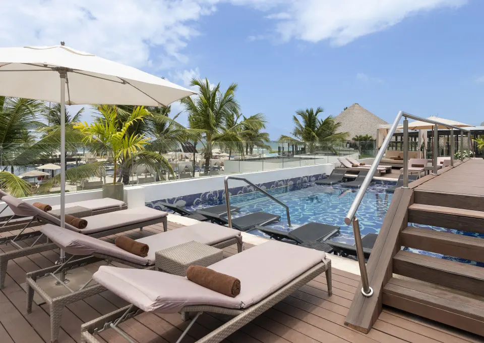 Pool deck loungers and ocean-facing palms at Royalton CHIC Punta Cana Resort & Casino.