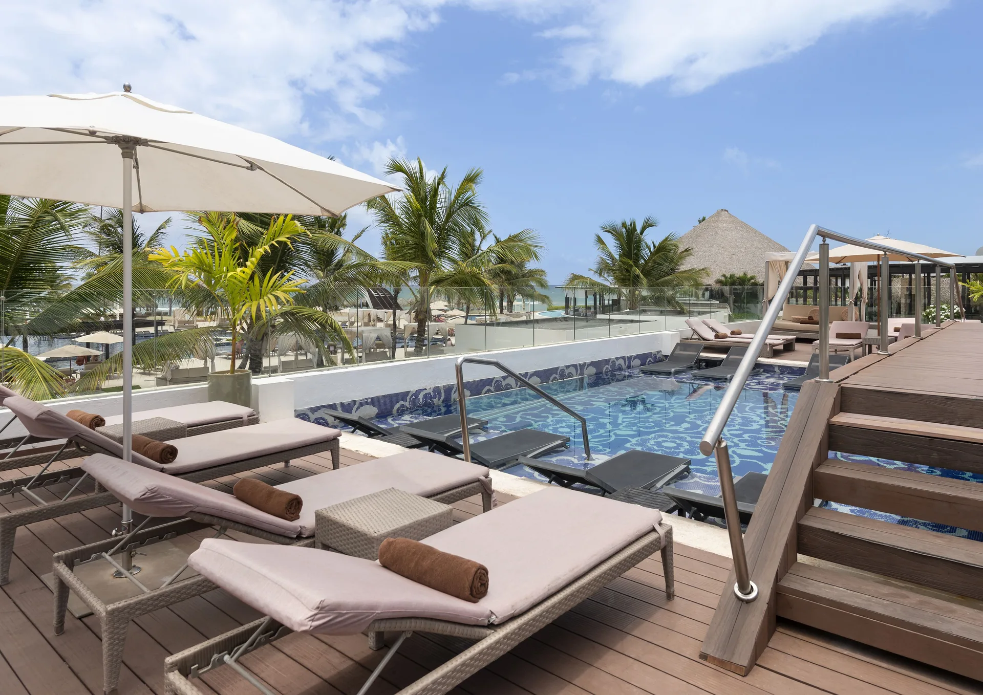 Pool deck loungers and ocean-facing palms at Royalton CHIC Punta Cana Resort & Casino.