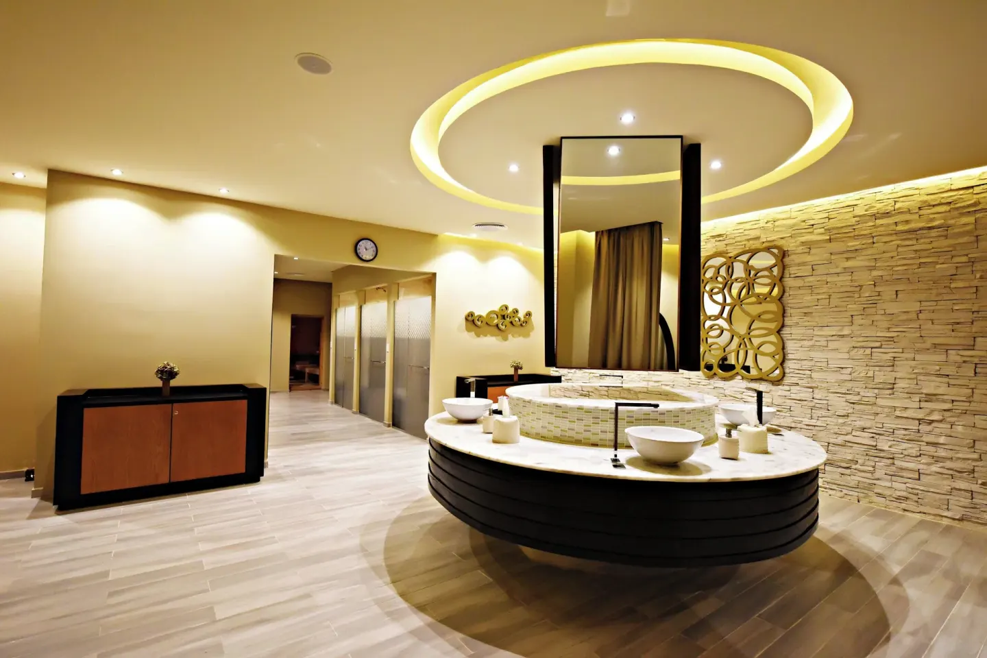 Spa vanity area with round sinks and stone wall at Royalton CHIC Punta Cana Resort & Casino.