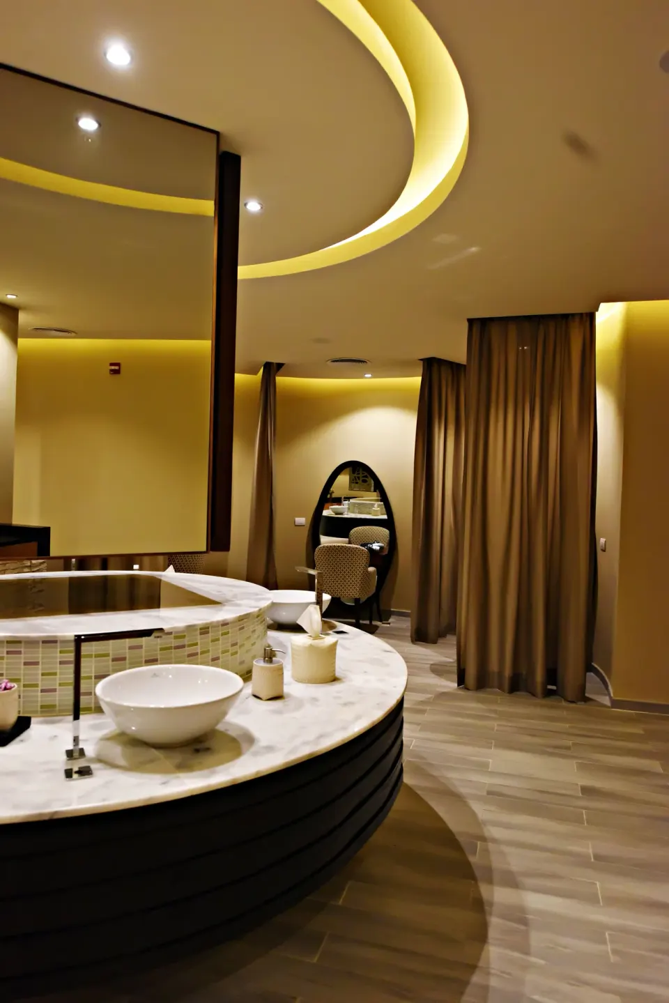 Spa vanity area at Royalton CHIC Punta Cana Resort & Casino with a round counter and curtained alcoves.