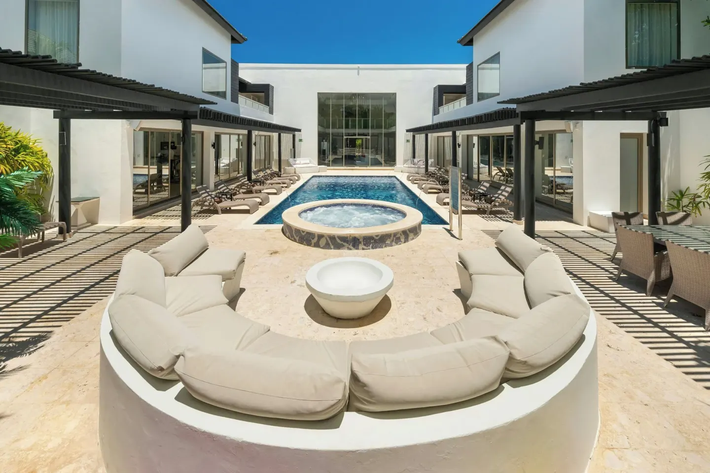 Sunlit courtyard pool with circular seating at Royalton CHIC Punta Cana Resort & Casino.