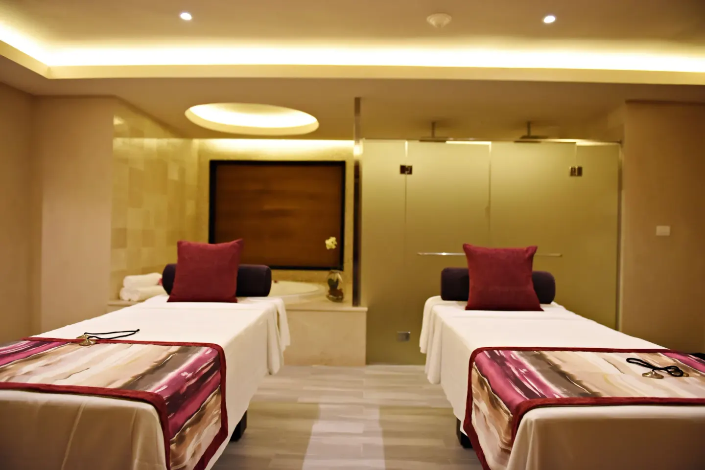 Twin spa treatment beds at Royalton CHIC Punta Cana Resort & Casino facing showers and a tub.