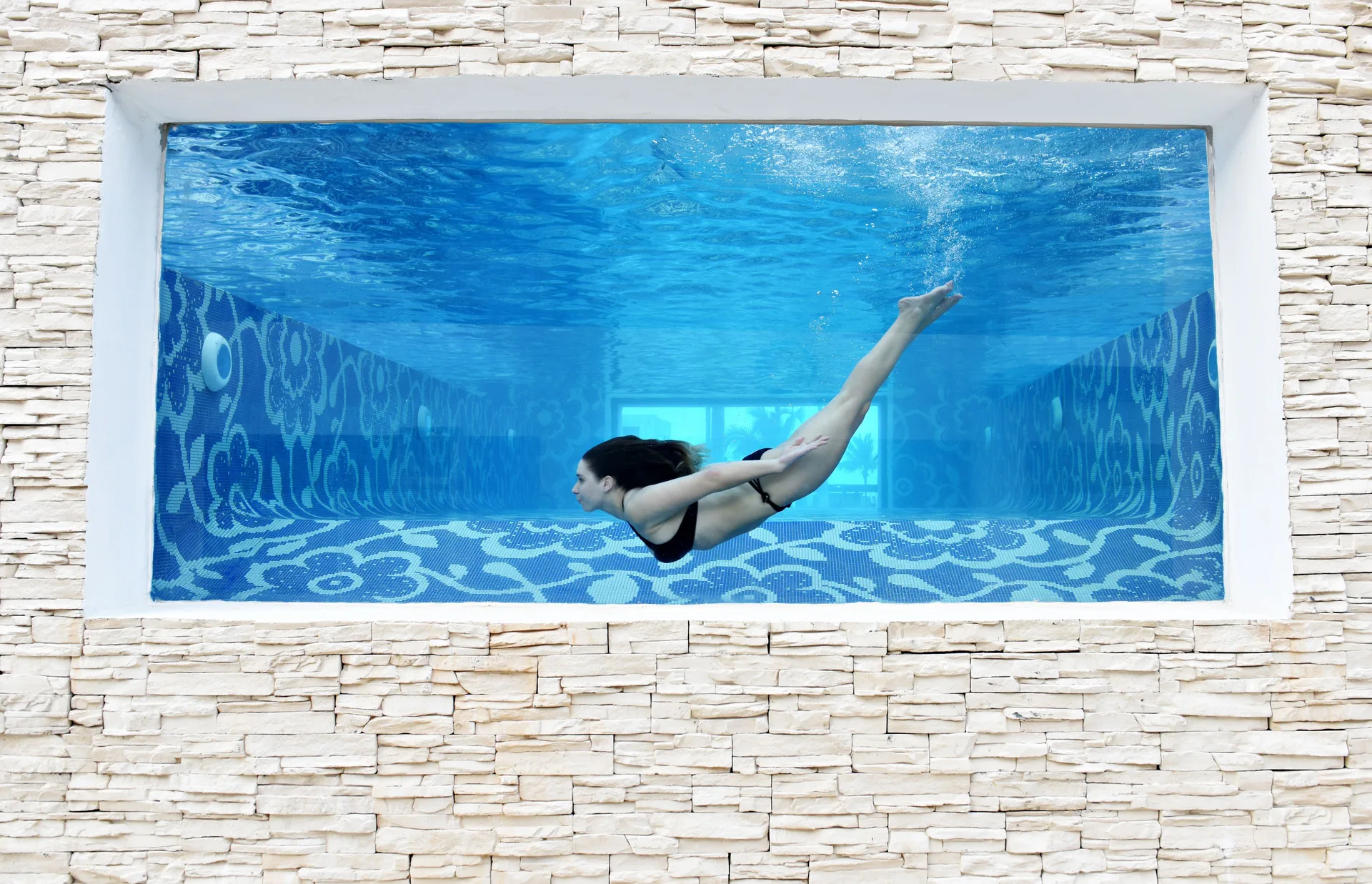 Underwater swimmer seen through a pool window at Royalton CHIC Punta Cana Resort & Casino.