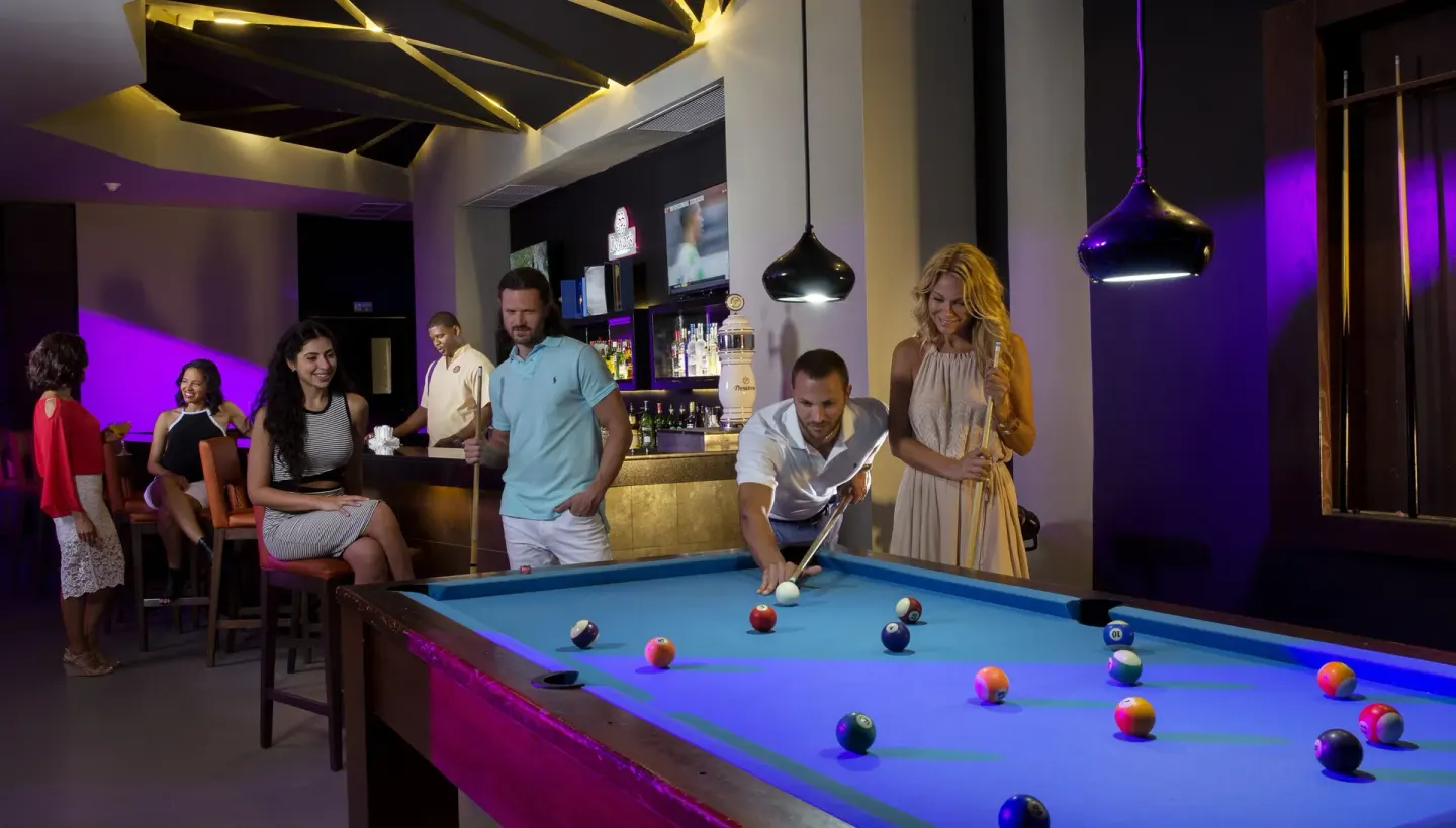 Guests play pool in a bar lounge at Royalton CHIC Punta Cana Resort & Casino.