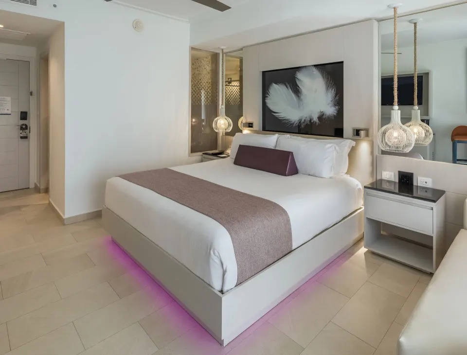 Luxury Room king bed with pendant lights at Royalton CHIC Punta Cana Resort & Casino.