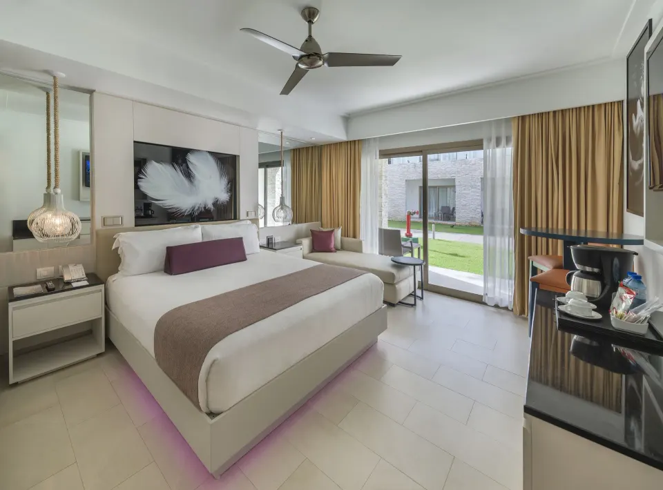 Luxury Room king bed, sitting area and patio doors at Royalton CHIC Punta Cana Resort & Casino.